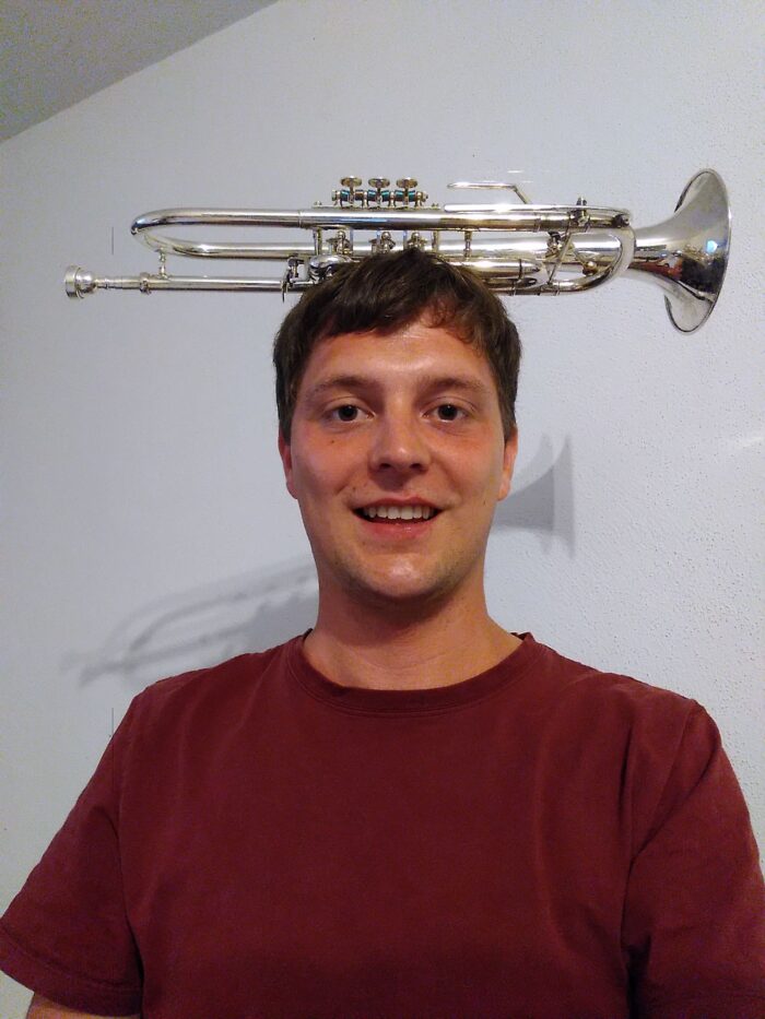 Stefan Rehrl balanciert eine Trompete auf dem Kopf